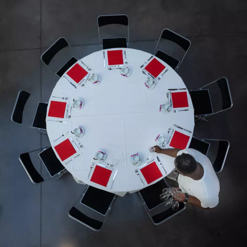 Photographie réalisée dans le cadre d'un reportage métier pour l'entreprise Prestal : un salarié dresse une table avant l'arrivée des convives. © Bertrand Perret