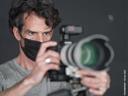 Portrait de Bertrand Perret en train de prendre une photo avec son appareil photo Sony A7R4 pour illustrer l'article qui présente son travail